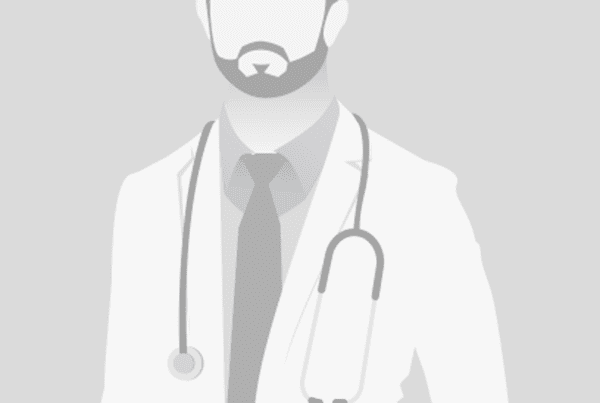 Illustration of a male doctor with no facial features, wearing a white coat, shirt, and tie. A stethoscope is draped around his neck. The background is plain gray.