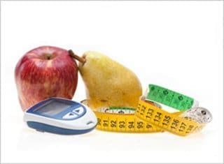 A red apple, a pear, a glucometer, and two measuring tapes, one yellow and one green, are arranged on a white surface.